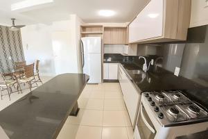 cocina con encimera negra y nevera en Apartamento com vista mar em excelente localização, en Bombinhas