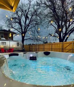 uma banheira de hidromassagem num quintal com árvores e uma cerca em Chic 50s Time Capsule Downtown/OU Med/OK Capitol em Oklahoma City