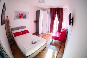 a small room with a bed and a red chair at Strambio28 in Milan