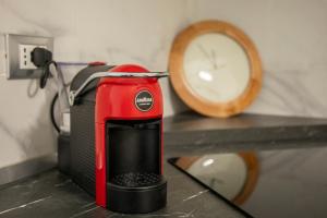 un tostapane rosso seduto su un bancone accanto a un orologio di Strambio28 a Milano