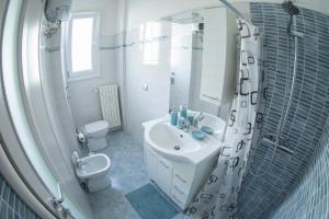 a white bathroom with a sink and a shower at Strambio28 in Milan