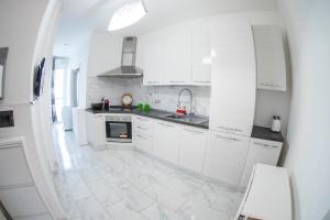 una cucina con armadietti bianchi e pavimento piastrellato bianco di Strambio28 a Milano Altre 5 foto