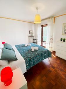 1 dormitorio con 1 cama con colcha azul y verde en Spacious apartment with terrace with mountain view en Moggio