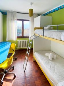 1 dormitorio con 2 literas y silla amarilla en Spacious apartment with terrace with mountain view en Moggio