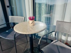 a table with a vase of flowers on it at Nova Galerija Studio App Bella,Lara,Katy - parking in garage in Zagreb