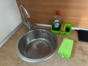 a stainless steel sink with a bottle of detergent next to it at Louie Louie Apartment Old Town in Tarragona