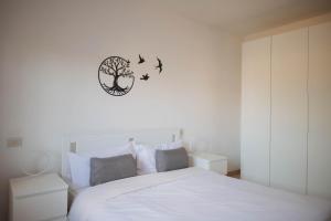 ein Schlafzimmer mit einem weißen Bett mit Vögeln an der Wand in der Unterkunft [Casa Ghandi] 20 min da Roma + Box Auto + Wi-Fi + Self Check-In in Monterotondo