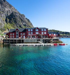 um grande edifício vermelho sobre uma doca na água em Lofoten Å HI hostel em Å