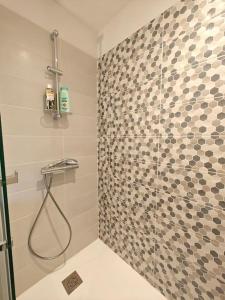 y baño con ducha y pared de azulejos. en T2 à proximité des commerces - 1 à 4 pers -, en Langon