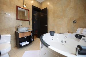 ein Badezimmer mit einer Badewanne, einem WC und einem Waschbecken in der Unterkunft Chakana Hotel Boutique Mariscal in Quito