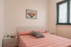 - une chambre dotée d'un lit avec des draps à rayures orange dans l'établissement Casa Dolce Casa, à Sarnico