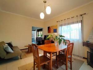 uma sala de jantar com uma mesa de madeira e cadeiras em Eucalyptus Pink House em Covelo