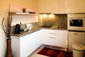 uma pequena cozinha com armários brancos e um micro-ondas em Eucalyptus Pink House em Covelo