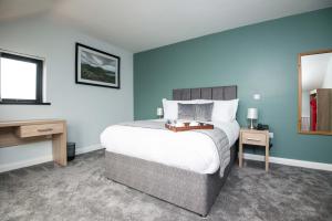 a bedroom with a bed and a table and a mirror at Standing Stones Lodge in Belfast
