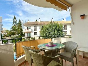 d'une terrasse avec une table et des chaises sur un balcon. dans l'établissement Bonito Apartamento Con Piscina y Jacuzzi, à L'Alfàs del Pi