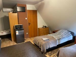 1 dormitorio pequeño con 1 cama y TV en NOCLEGI-SPŁYWY BUGIEM, en Sławatycze