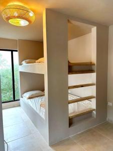 a room with two bunk beds in a wall at VillaMaya- Hidden City Oasis in Mayaguez