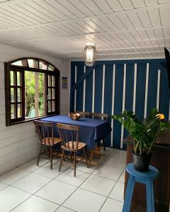 uma sala de jantar com uma mesa azul e cadeiras em Bela Vista - Casa Beira Mar em Paranaguá