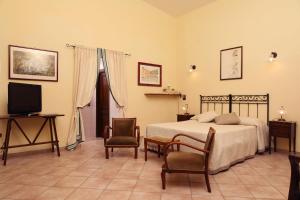 a bedroom with a bed and a tv and chairs at Le Cese in San Giovanni Rotondo