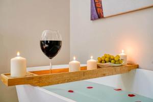 a shelf with candles and a glass of wine at Eden Suite Paris la Defense in Courbevoie