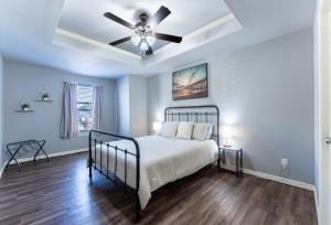 a bedroom with a bed and a ceiling fan at Modern Home 10 minutes from Dickson St & U of A in Fayetteville