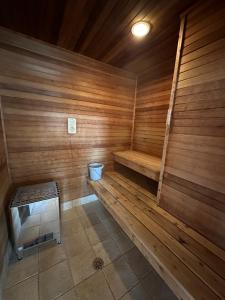 a wooden sauna with a bench and a toilet in it at Birchwood Lodge in Sister Bay
