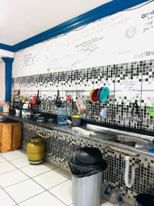 a kitchen with a counter with alot of dishes at adriana hostel in Itacaré