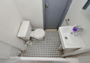 y baño con aseo blanco y lavamanos. en Bright & Cozy 3BD Apartment In Mid West, en Nueva York