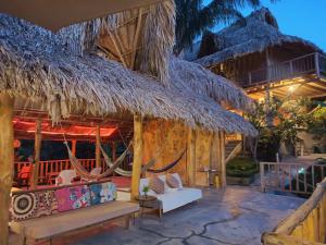 a resort with a hammock and a thatch roof at Frana Lodge in El Zaino