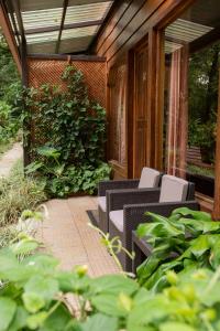 un patio al aire libre con sillas y un seto en Cala Lodge en Monteverde Costa Rica