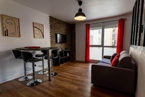 ein Wohnzimmer mit Tisch und Couch in der Unterkunft Les conviviales Quartier théâtre gare in Sète