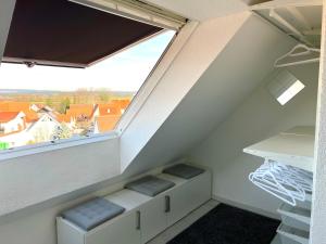 een zolderkamer met een balkon en een raam bij Luxus Maisonette Wohnung, Apartment am See, Wehome Komfort in Sankt Leon-Rot