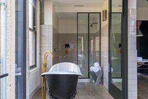 La salle de bains est pourvue d'une grande baignoire et d'une douche. dans l'établissement STILE Downtown Los Angeles by Kasa, à Los Angeles