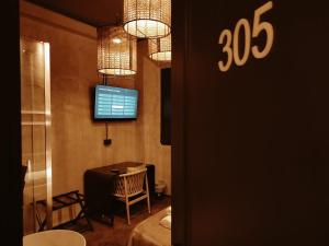 Hostel 7 في فلورنسا: غرفة مع طاولة وتلفزيون على الحائط