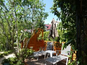 un patio con sombrilla, mesa y sillas en Ferienwohnung "Waldblick", en Bad Liebenstein