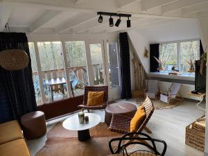 a living room with chairs and a table and windows at Woodhouse Durbuy nr. 141 in Durbuy