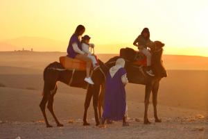 un grupo de gente montando a caballo en el desierto en Dar Inacamp 