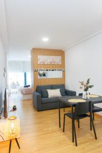 sala de estar con sofá y mesa en Apartamentos Coruña Vip Centro, en A Coruña