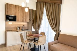 a kitchen and living room with a table and chairs at Apartmány Hájenka Oravice in Oravice