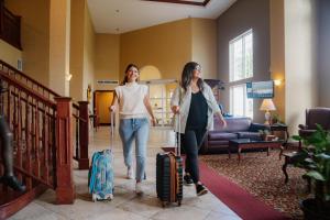 dos mujeres bajando las escaleras con su equipaje en Four Seasons Island Resort en Pembine