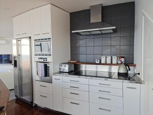 a kitchen with white cabinets and a stainless steel refrigerator at Starship Enterprise in Wellington