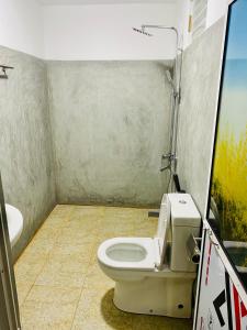 a bathroom with a toilet and a sink at Indika Beach Villa in Galle