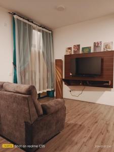 una sala de estar con un sofá y un televisor en l Brand New Condo l I-Muslim Guesthouse Kuala Lumpur, en Kuala Lumpur