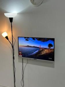 telewizor z płaskim ekranem wiszący na ścianie w obiekcie Comfy 3BR Apartment Our Homestay Pusing Batu Gajah w mieście Pusing