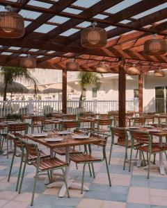 un restaurante con mesas de madera y sillas bajo un techo en Hotel Lucine, en Galveston