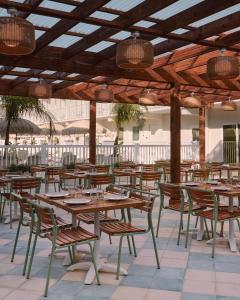 a restaurant with wooden tables and chairs under a roof at Hotel Lucine in Galveston
