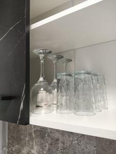 a shelf with glass bottles and glasses on it at Apartament HD2 in Hunedoara +18 photos