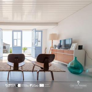 ein Wohnzimmer mit 2 Stühlen und einem TV in der Unterkunft T2 Casa das Pereiras in Calheta de Nesquim