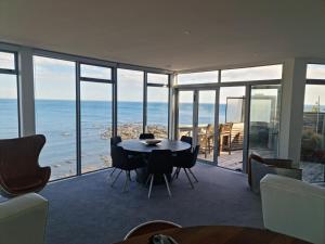 a dining room with a table and chairs and the ocean at Starship Enterprise in Wellington