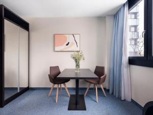 - une salle à manger avec une table et des chaises dans l'établissement numa I Viktoria Apartments, à Munich